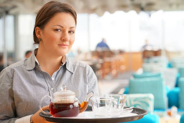 Girl working as waitress holding a tray with tea — Stock Photo, Image