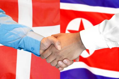 Danimarka ve Kuzey Kore bayrağı arka planda el sıkışma.