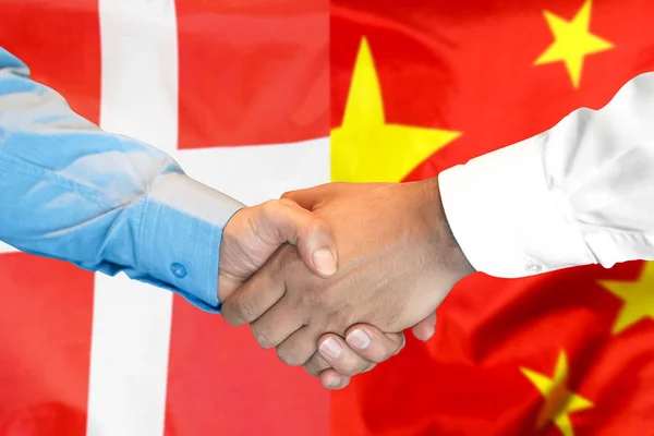 handshake on Denmark and China flag background.