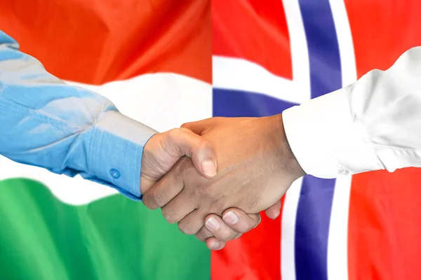 Handshake op Hongarije en Noorwegen vlag achtergrond. — Stockfoto