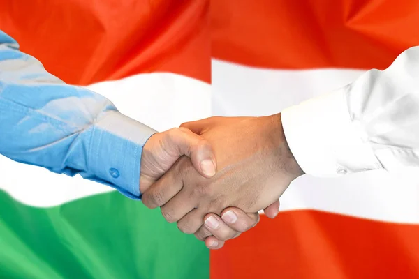 Aperto de mão sobre a Hungria e Áustria bandeira de fundo . — Fotografia de Stock