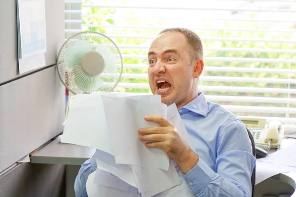 Zakenman op zijn Bureau gooit documenten en papieren in de lucht — Stockfoto