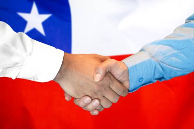 Şili bayrağı arka planda el sıkışma.