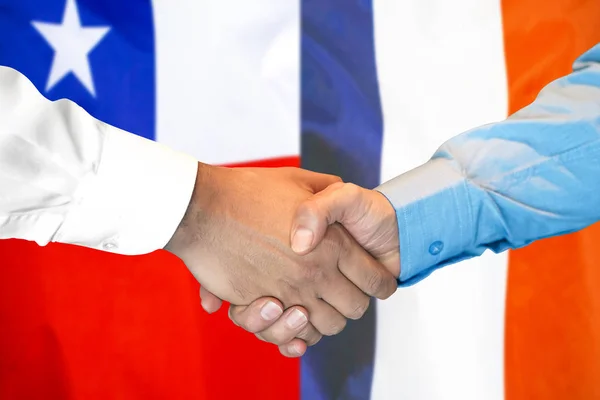 Podání ruky na pozadí vlajky Chile a Francie. — Stock fotografie