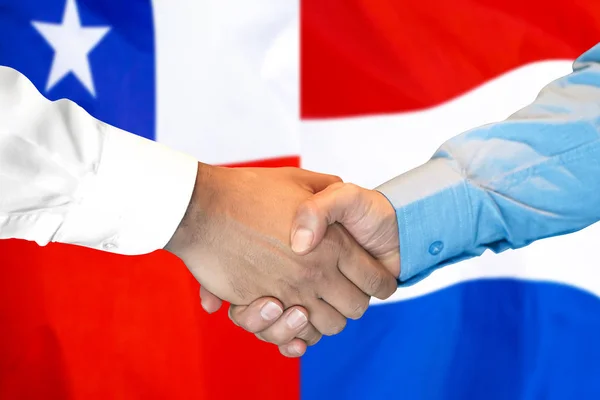 Podání ruky na pozadí vlajky Chile a Nizozemsko. — Stock fotografie