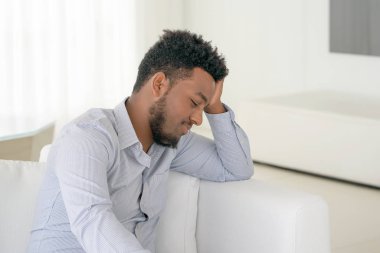 üzgün Afrika adam yatakta yatıyor.