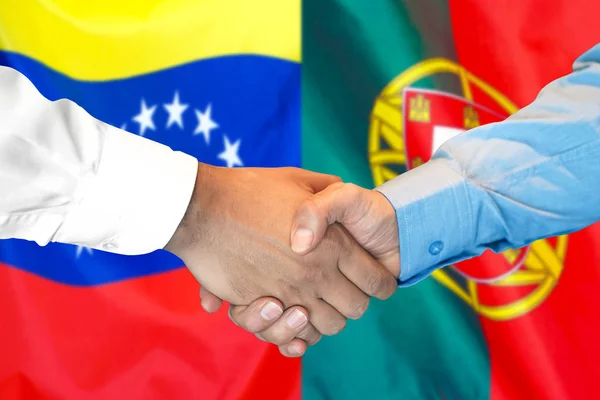 Mano apretada sobre fondo de bandera de Venezuela y Portugal . — Foto de Stock