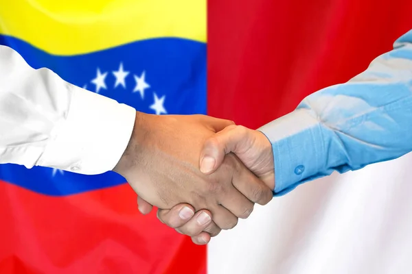 Venezuela ve Monako bayrak arka plan üzerinde El sıkışma. — Stok fotoğraf