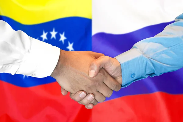 在委内瑞拉和俄罗斯国旗背景握手. — 图库照片