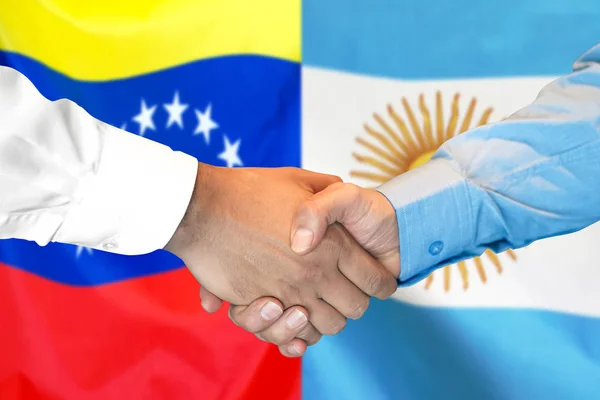 委内瑞拉和阿根廷国旗背景握手. — 图库照片