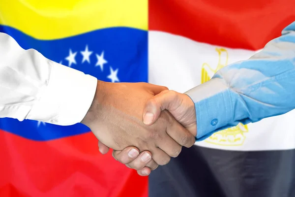 Mano apretada sobre fondo de bandera de Venezuela y Egipto . — Foto de Stock