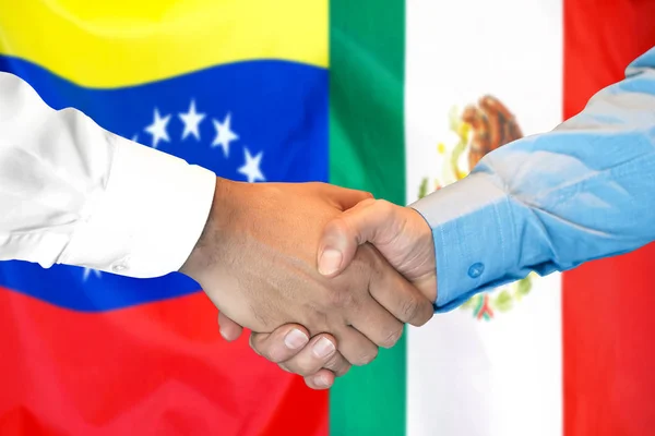 Mano apretada sobre fondo de bandera de Venezuela y México . — Foto de Stock