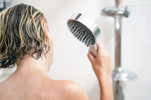 Kız bir duş sulama el tutar