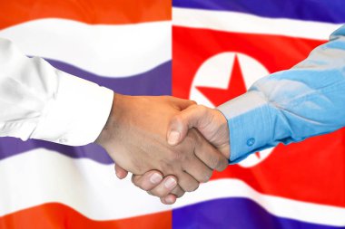 El sıkışma Tayland ve Kuzey Kore bayrağı arka plan.