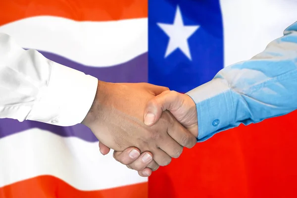 Podání ruky na pozadí vlajky Thajska a Chile. — Stock fotografie