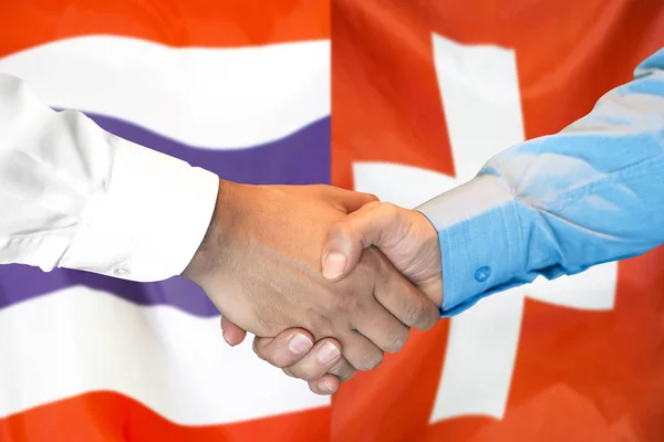 Handskakning om Thailand och Schweiz flagga bakgrund. — Stockfoto