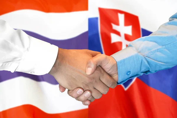 Podání ruky na pozadí vlajky Thajska a Slovenska. — Stock fotografie