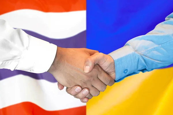 Poignée de main sur fond drapeau Thaïlande et Ukraine . — Photo