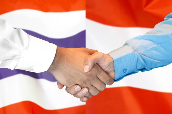 Jabat tangan di Thailand dan Austria bendera latar belakang . — Stok Foto