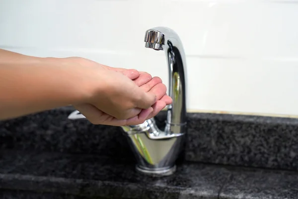 Mão feminina verifica a água na torneira — Fotografia de Stock