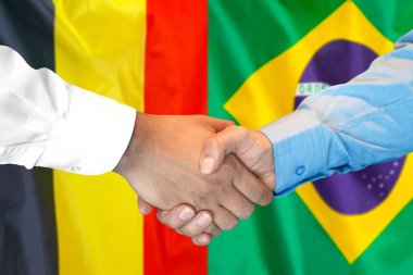 Belçika ve Brezilya bayrağı arka planda el sıkışma.