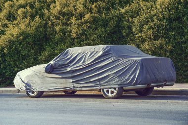 Güneş havasında koruyucu kılıfı olan park etmiş bir araba