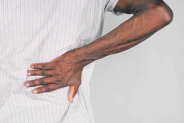 Elderly african man, pain at lower back.