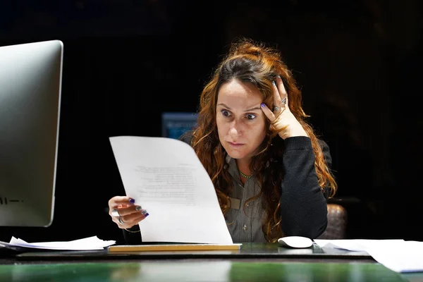 business woman reading a document in office workspace