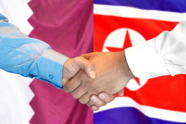 Katar ve Kuzey Kore bayrağı arka plan üzerinde El sıkışma.