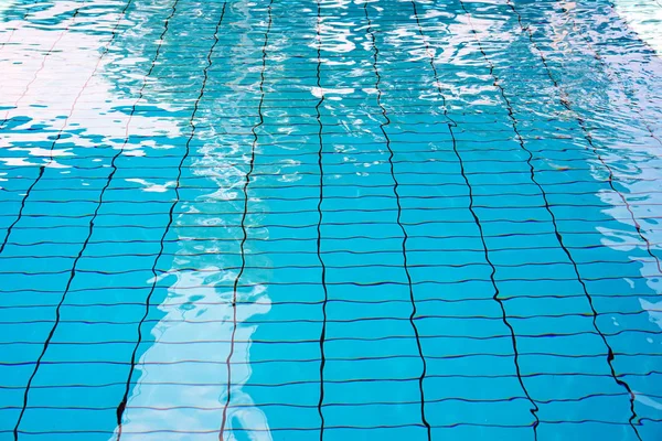 Textúra a víz a medencében. Üres beltéri gyermekmedence, Fitness Club nyilvános uszoda. Gyermek medence napos gondolatokkal. — Stock Fotó