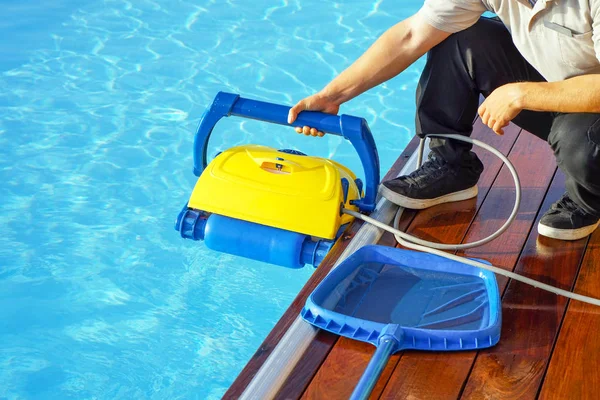 Hotel staff worker cleaning the pool. Automatic pool cleaners. — Stock Photo, Image