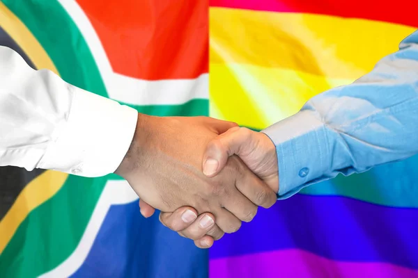 Handshake on South Africa and LGBT gay flag background. — Stock Photo, Image