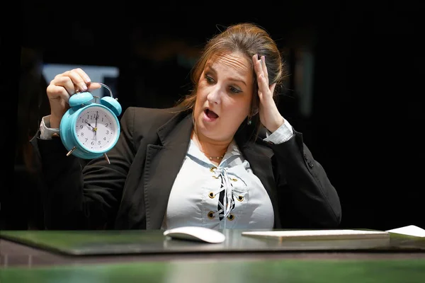 Woman holding a clock. Woman holds an alarm clock in her hand