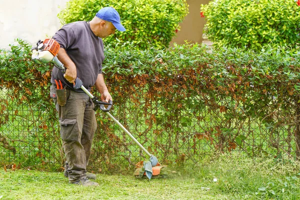 Man cutting grass in a park — Stock Photo, Image