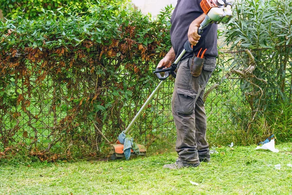 Homem cortando grama em um parque — Fotografia de Stock