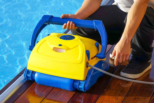 Trabajador del hotel limpiando la piscina. Limpiadores automáticos de piscinas . —  Fotos de Stock