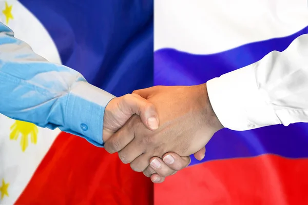 Handshake on Philippines and Russia flag background. — Stock Photo, Image