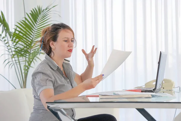 Деловая женщина читает документ в офисном рабочем пространстве — стоковое фото