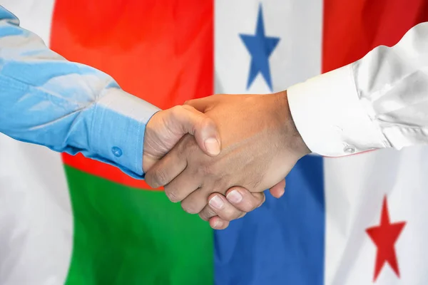 在两面旗帜的背景下进行商业握手 男子在马达加斯加和巴拿马国旗的背景下握手 支助概念 — 图库照片