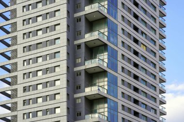 Gökdelen inşa eden modern şehrin ön cephesinin cam mavisi pencereleri. Binanın balkonları. Yeni mahalledeki modern apartmanlar. Soyut mimari. Doku.