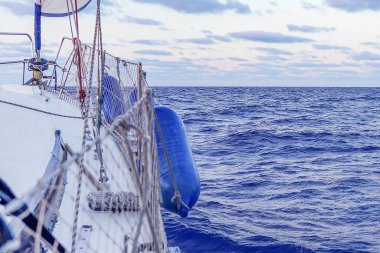 Yelkenli teknenin deniz manzarası geniş. Yelkenli altında denizde yüksek hızda yelken açarken arka planda deniz olan yelkenli yarışı sırasında güçlü bir rüzgarda. Yatçılık lüks bir spor ve harika bir tatil. Çökmüş ufukta.
