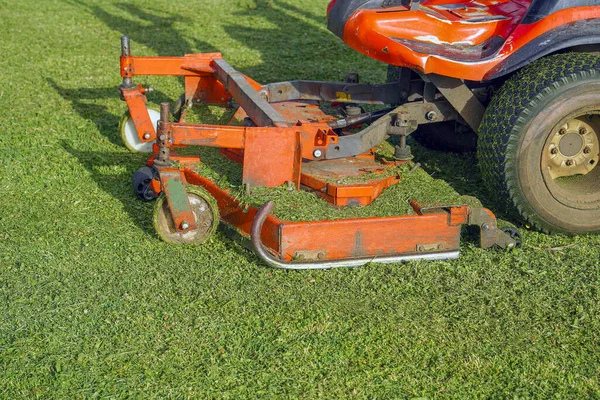 芝生のケア ライディング モーワー 緑の芝生の背景に機械の芝刈り機 — ストック写真