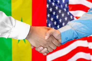 İki bayrağın arka planında iş tokalaşması. Senegal ve Amerika Birleşik Devletleri bayrağının arka planında erkek tokalaşması. Destek konsepti.