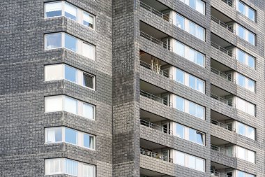 Yeni mahalledeki modern apartmanlar. Pencereleri olan eski gri tuğla bir duvar. Pencereli eski gri tuğla duvar.