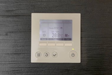 Klima kontrol paneli. Siyah tahta duvarda dijital termostat var. Termostat dijital programlanabilir.