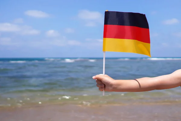 在地平线上握住德国国旗的小女孩的手 10月3日德国独立日 — 图库照片