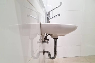 Havaalanında ya da restoranda, kafede umumi tuvalette. Beyaz lavabonun içi modern tasarımla dolu. Banyoya yakın çekim..