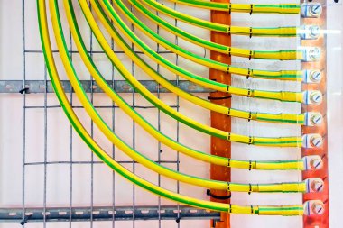 Duvarda yüksek voltajlı bakır kablolar var. Elektrikli bar. Elektrik zemin çubuğuna bağlı kablolar. Kontrol sistemi için zemin sektörü.