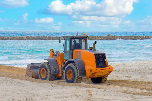 Bulldozer and a panoramic view of the sea. Yellow bulldozer in front of the sea.