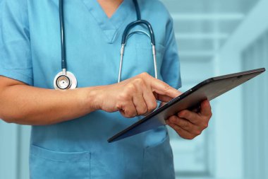 Sağlık ve ilaç servisi. Dijital tablet kullanan bir doktor ya da cerrah. Tıbbi ekipman ya da tıbbi ağ. Doktor dijital tablet kullanıyor..